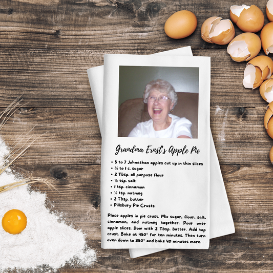 Recipe card for Grandma Ernst's Apple Pie with a photo of an elderly woman on a wooden surface with eggs and flour.
